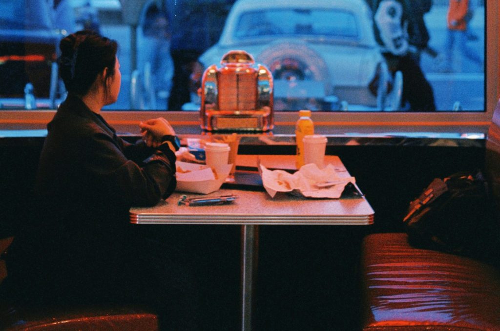 a woman sitting at a table in front of a window